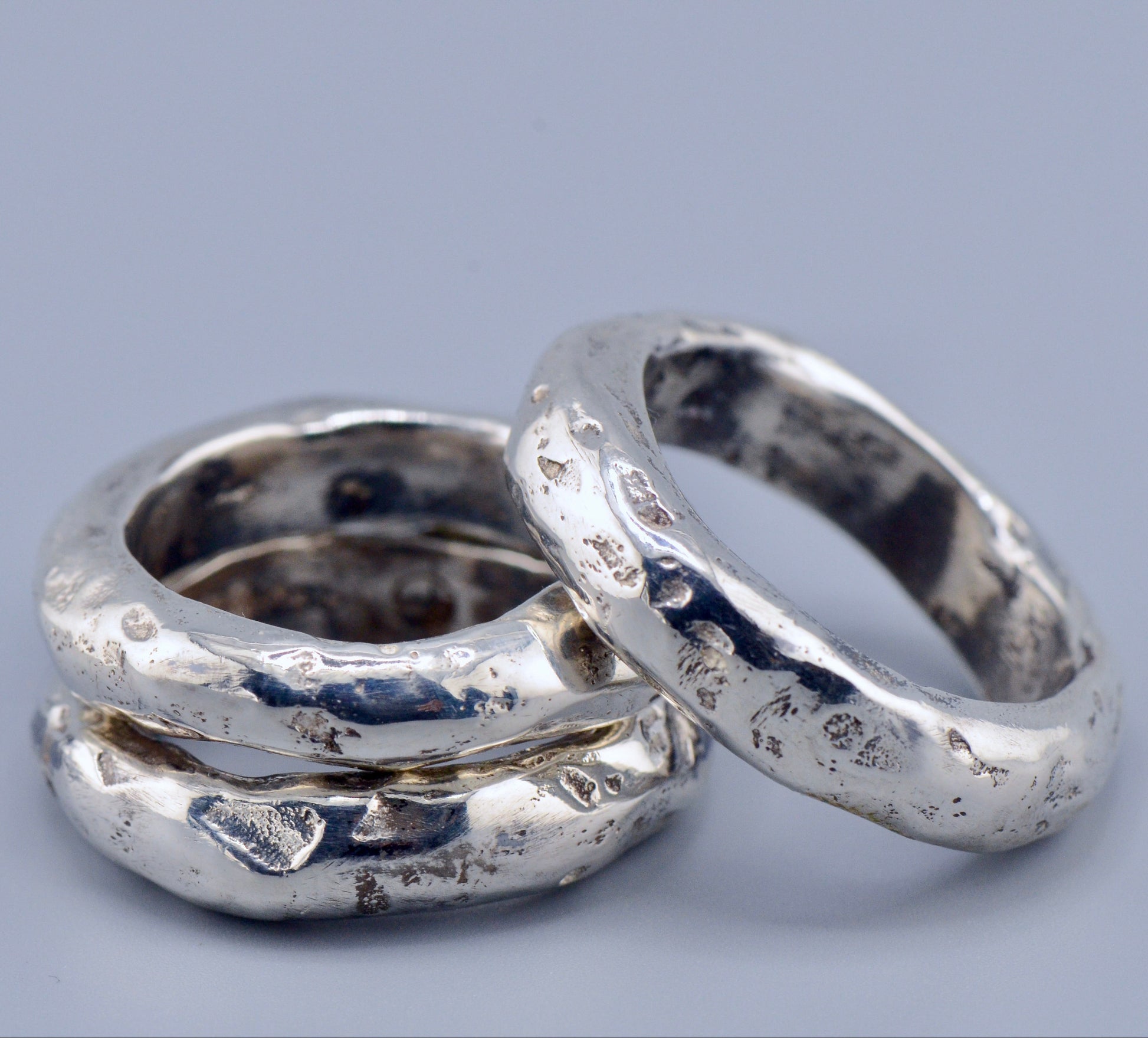 3 silver rings on a gray background