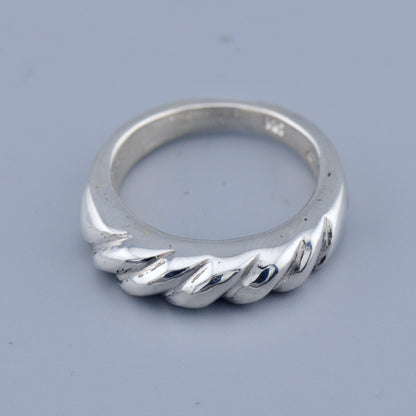 Silver twisted ring on a gray background